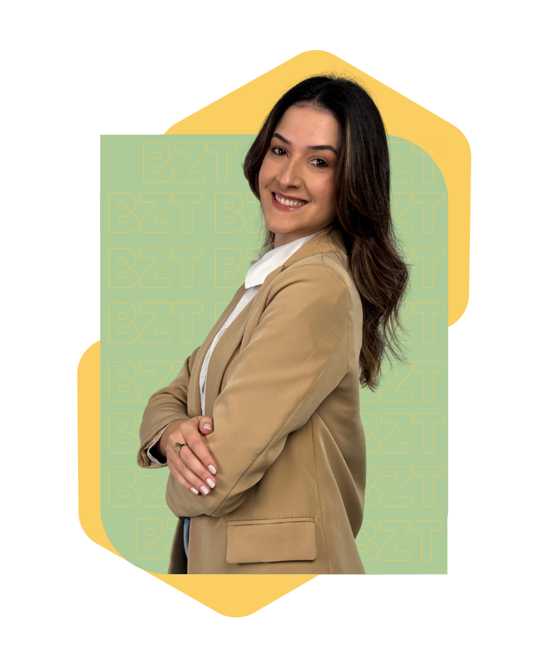 mulher em pose de 3/4 com braços cruzados olhando para a câmera sorrindo